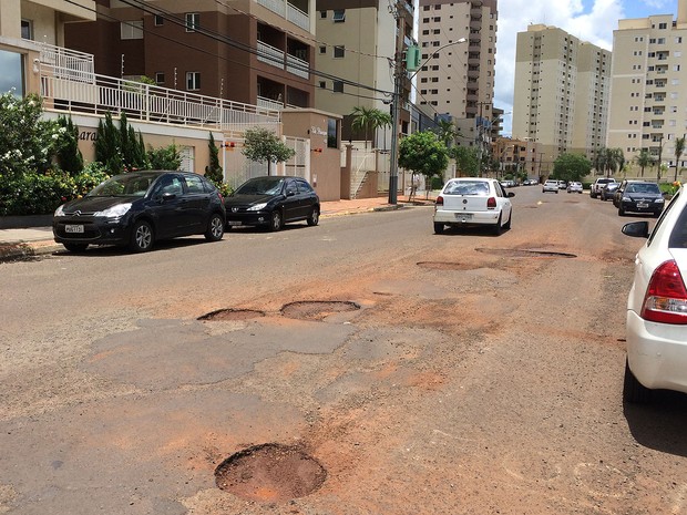 Motoristas precisam seguir na contramão para desviar de buracos na Rua Magda Perona Frossard, em Ribeirão Preto (Foto: Thaisa Figueiredo/G1)