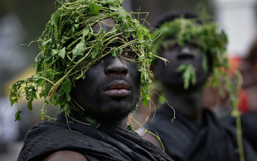Seguranças de um chefe tribal ganês usam preto e folhas em suas cabeças, uma tradição durante funerais, durante o velório do ex-secretário Geral da ONU em Acra, Gana, na quarta-feira (12) — Foto: AP Photo/Sunday Alamba