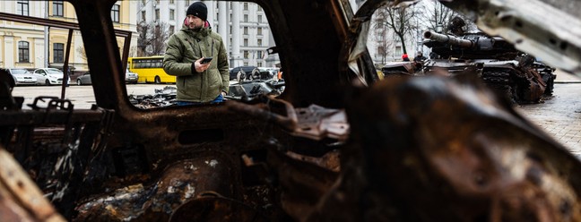 Pedestre observa veículos militares russos destruídos em uma exposição ao ar livre em Kiev, Ucrânia — Foto: SAMEER AL-DOUMY/AFP