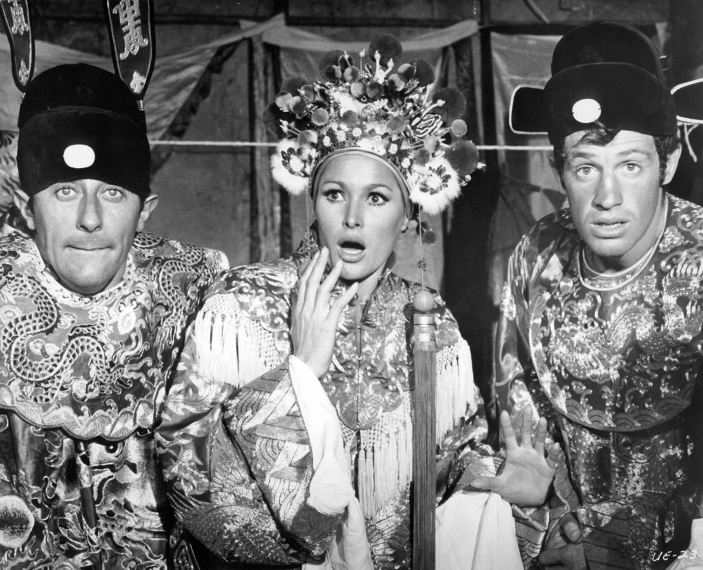 Jean Rochefort, Ursula Andress, and Jean-Paul Belmondo all wearing Chinese mandarin robes in a scene from the film 'Up To His Ears', 1965. (Photo by Lopert Pictures/Getty Images) (Foto: Getty Images)