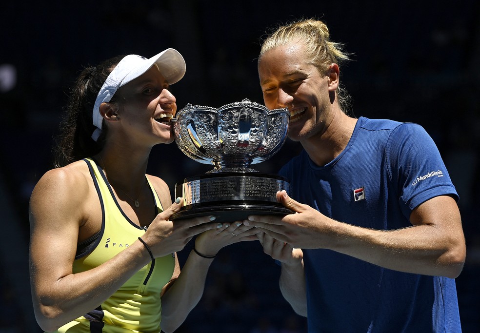 Luisa Stefani e Rafa Matos mordem o troféu do Australian Open — Foto: Jaimi Joy/Reuters