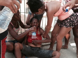 Moradora passa mal durante reintegação de posse de terreno no Rio (Foto: Guilherme Brito/G1)
