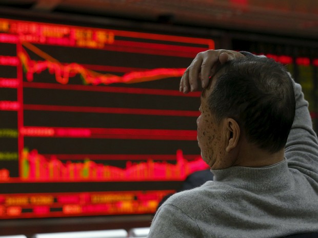 Homem observa painel eletrônico na bolsa de valores de Pequim, na China, nesta segunda-feira (4) (Foto: Kim Kyung-Hoon/Reuters)