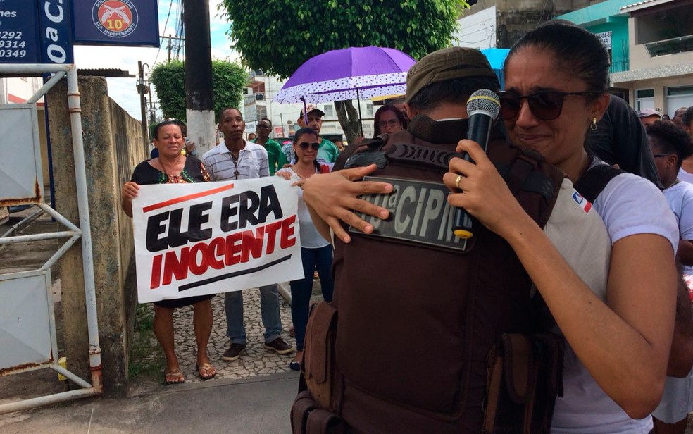 Policial militar abra&ccedil;a filha de artista pl&aacute;stico morto em casa durante a&ccedil;&atilde;o da PM (Foto: Juliana Almirante/G1)