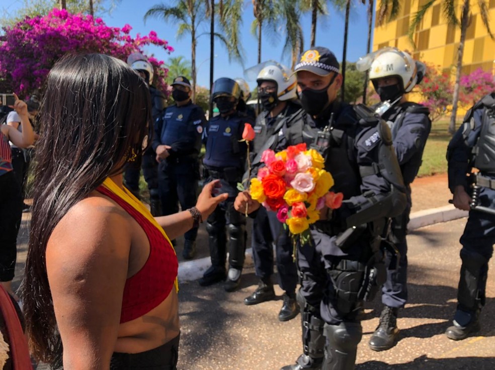 Indígenas entregam flores a PMs durante manifestação em Brasília — Foto: Walder Galvão/G1