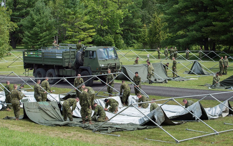Membros das Forças Armadas do Canadá montam tendas para solicitantes de asilo na fronteira entre o Canadá e os EUA em Lacolle, Quebec, na quarta (9) (Foto: Graham Hughes/The Canadian Press via AP)