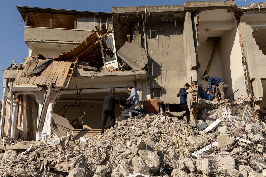 Pessoas recolhem itens em escombros na prov?ncia de Hatay, Turquia ? Foto: Eloisa Lopez/REUTERS