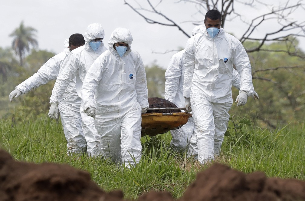 Equipe de resgate carrega uma das vítimas encontradas em lama após rompimento de barragem em Brumadinho — Foto: Andre Penner/AP