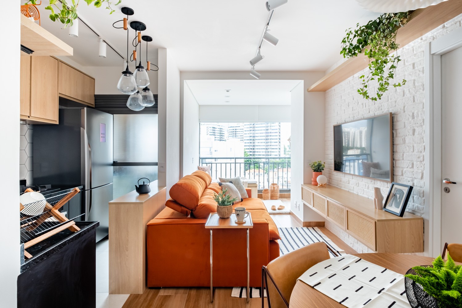 INTEGRAÇÃO | O sofá laranja é o destaque da sala de estar. A integração dos espaços permite a boa convivência. A marcenaria é assinada pela C&G Marcenaria Planejados  (Foto: Nathalie Artaxo / Divulgação)