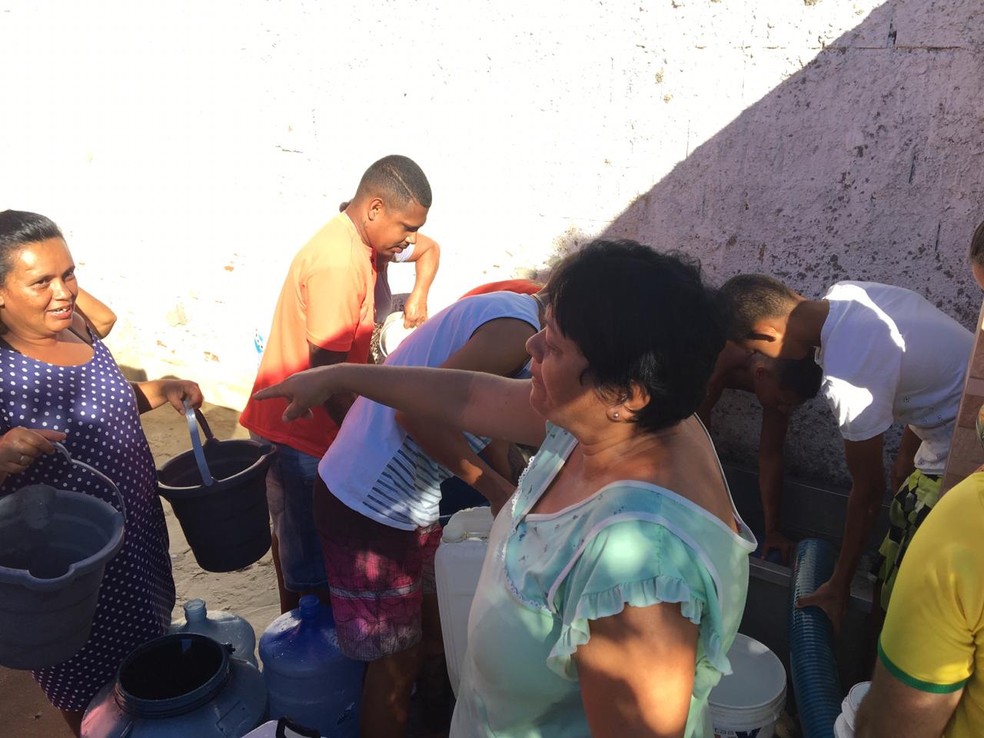 Vizinhos de Terezinha durante distribuição de água na manhã desta quarta, no bairro Três Irma, em Campina Grande — Foto: Felipe Valentim/TV Paraíba