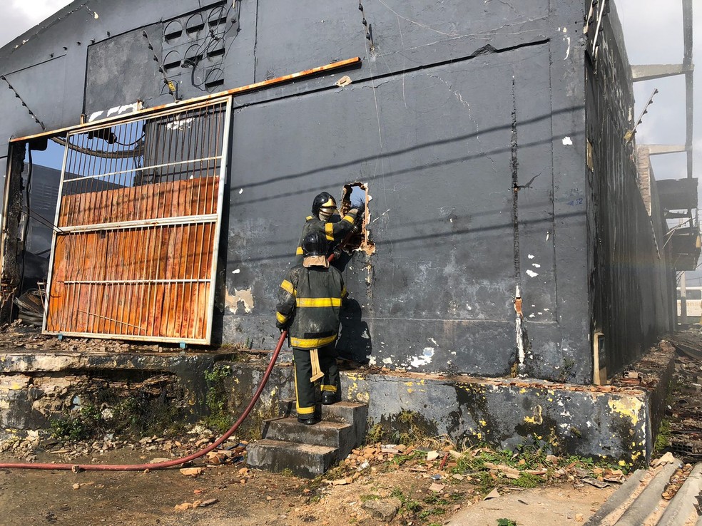 Bombeiros trabalham no rescaldo, após incêndio em loja de pneus em Parnamirim, na Grande Natal — Foto: Vinícius Marinho/Inter TV Cabugi
