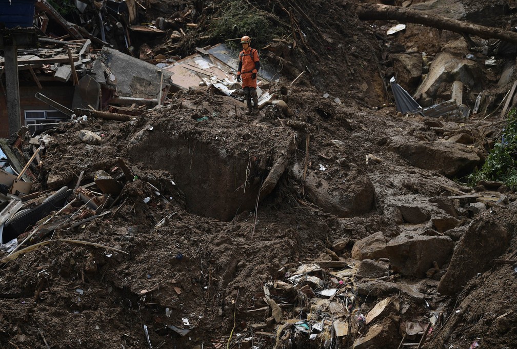 Integrante da equipe de buscas dos bombeiros trabalha no local do deslizamento no Morro da Oficina, em Petrópolis (RJ), nesta quarta (16) — Foto: Carl de Souza/AFP