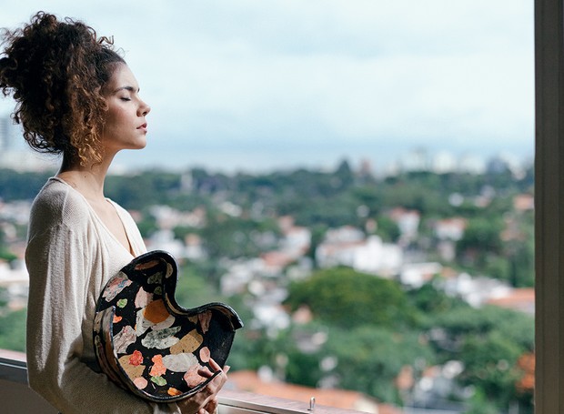Ela está na varanda de seu apartamento em São Paulo e segura a bandeja decorativa Fernanda, 23 x 20 cm, R$ 1.400 (Foto: Mayra Azzi / Editora Globo)