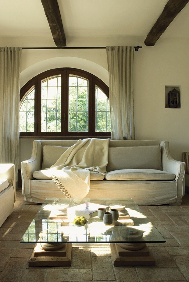 Pela sala de estar, que tem janelas em arco, pode-se acessar o pátio dos fundos desta casa, que fica na região italiana da Toscana (Foto:  Brando Cimarosti / Casa e Jardim)