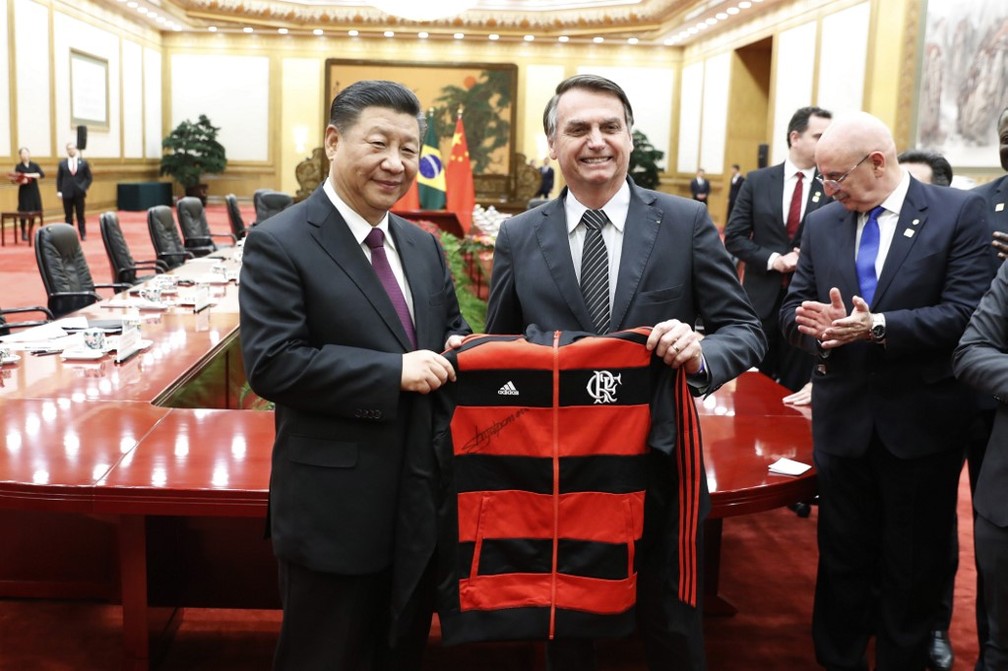 Presidente da China, Xi Jinping, recebe agasalho do Flamengo de Jair Bolsonaro em Pequim — Foto: Yukie Nishizawa/Pool/AFP