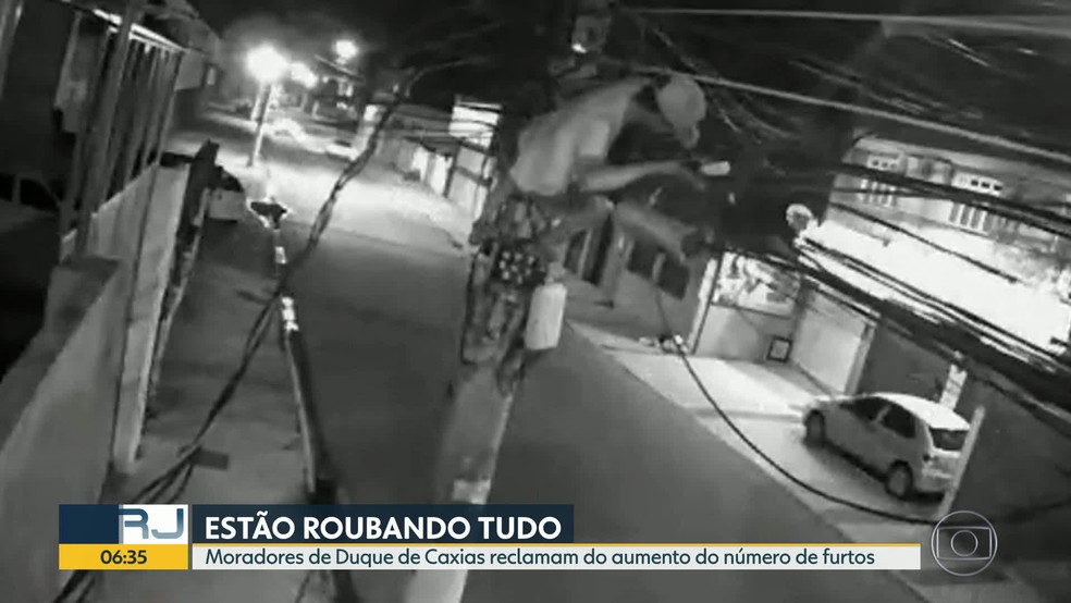 Câmeras de segurança flagraram homem escalando poste para roubar fios de cobre — Foto: Reprodução / TV Globo