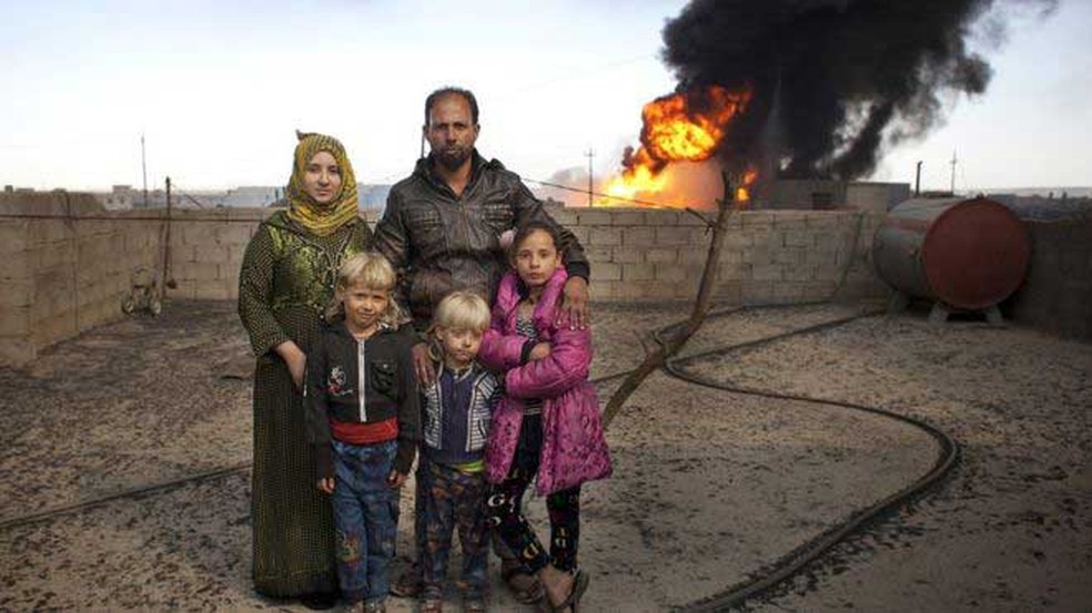 Ali Hassan, sua mulher Fatima Mahmoud e suas três crianças vivem perto de um poço de petróleo em chamas (Foto: Abbie Trayler-Smith/Oxfam)