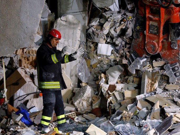 Bombeiro trabalha nas ruínas de uma casa que desmoronou após o terremoto em Amatrice, na Itália, na quarta (24) (Foto: Reuters/Stefano Rellandini)
