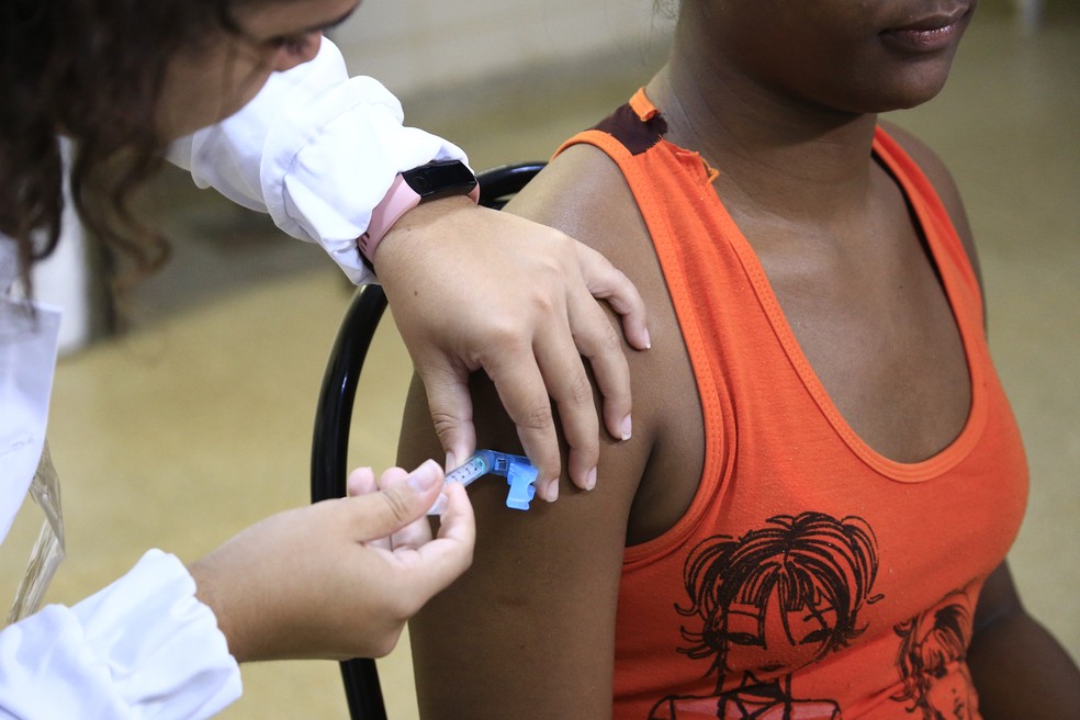 Servidora da Secretaria de Saúde do DF aplica vacina em adolescente — Foto: Breno Esaki/ Secretaria de Saúde