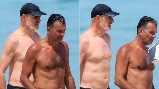 Marcos Caruso e namorado se refrescam no mar em dia de praia no Rio