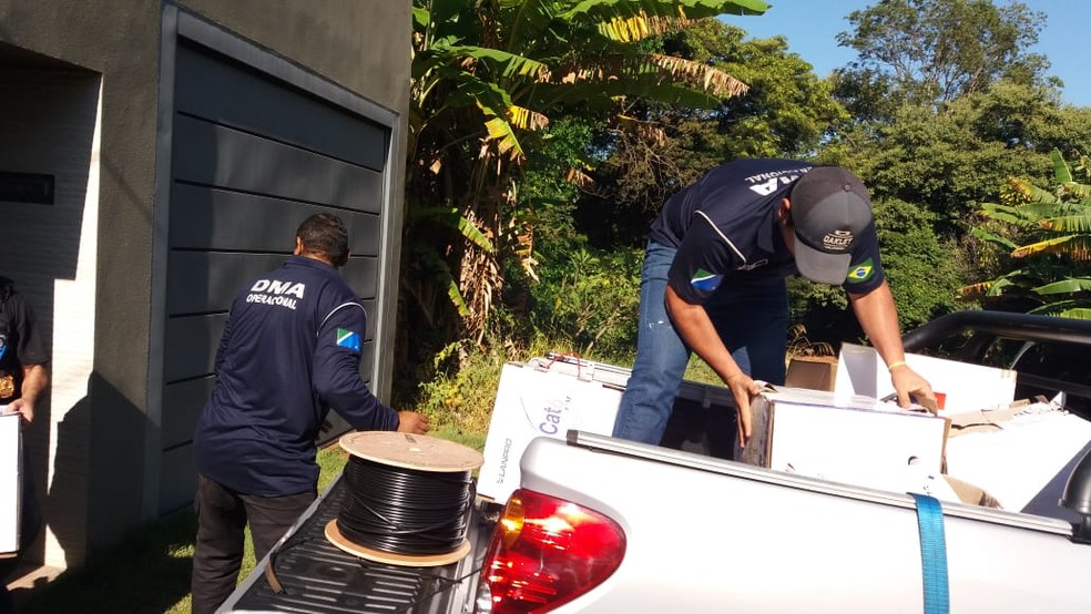 Agentes da PF e Receita Federal carregam veículo com mercadorias apreendidas na casa do empresário em Campo Grande — Foto: Osvaldo Nóbrega/TV Morena