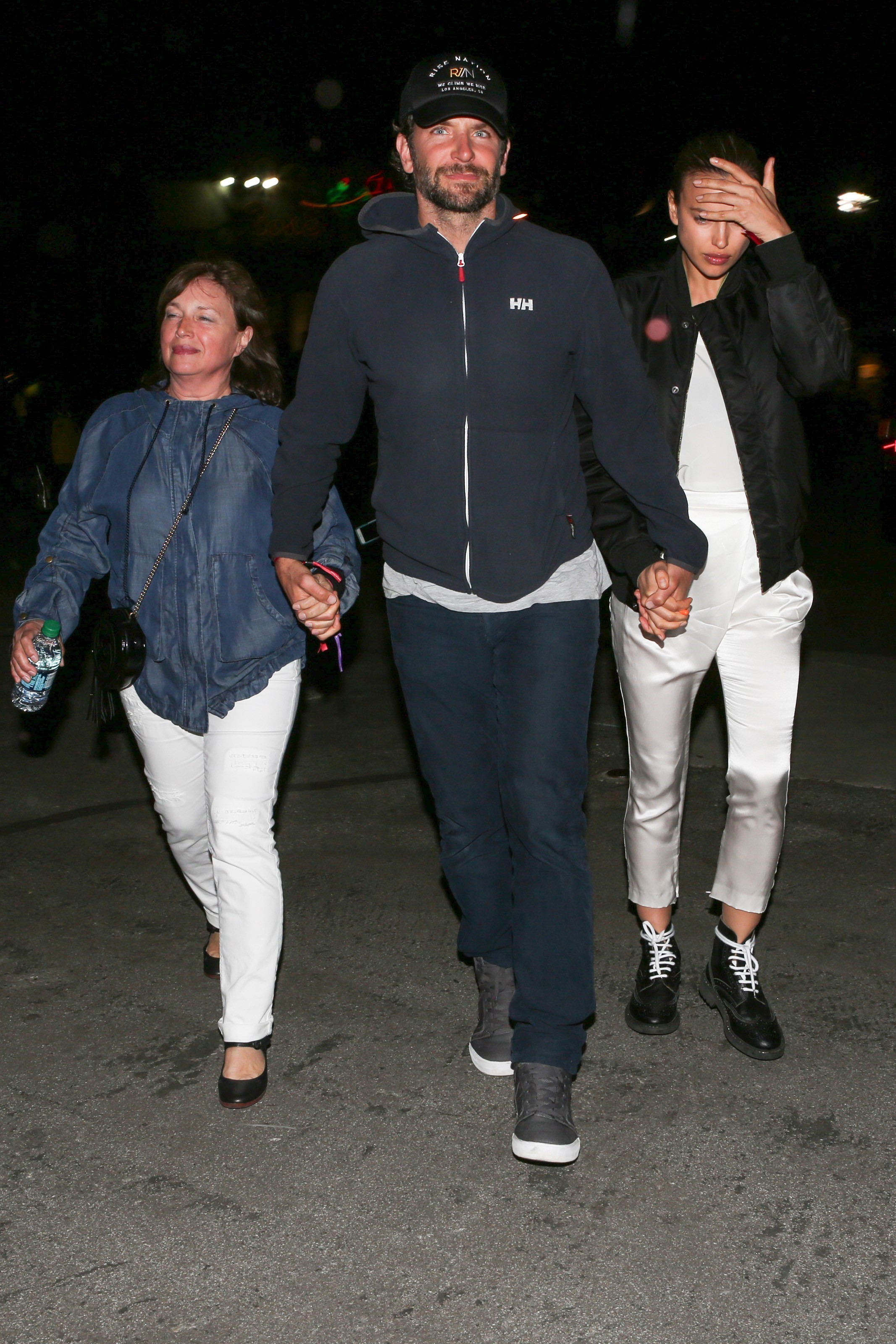 Bradley Cooper de mãos dadas com a namorada e a sogra na saída do show de Beyoncé (Foto: AKM-GSI)