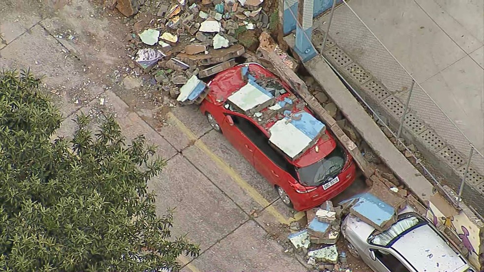 Muro de escola da Zona Sul caiu durante temporal e atingiu pelo menos três carros que estavam estacionados perto — Foto: Reprodução/TV Globo