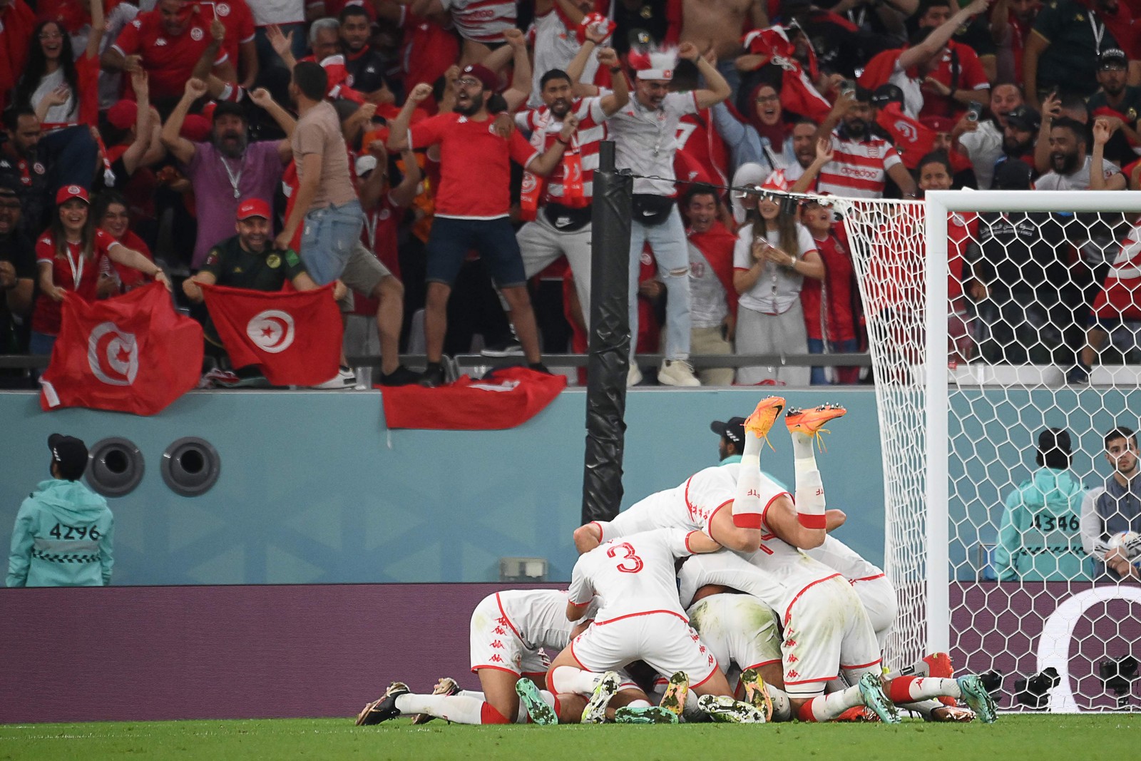 Jogadores da Tunísia se jogam em cima do atacante Wahbi Khazri autor do primeiro gol da partida — Foto: FRANCK FIPE/AFP