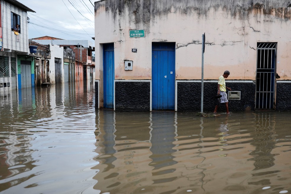 Homem anda por rua inundada após enchente em Itajuípe (BA), próxima a Itabuna, no sul da Bahia, na segunda-feira (27). — Foto: Amanda Perobelli/Reuters