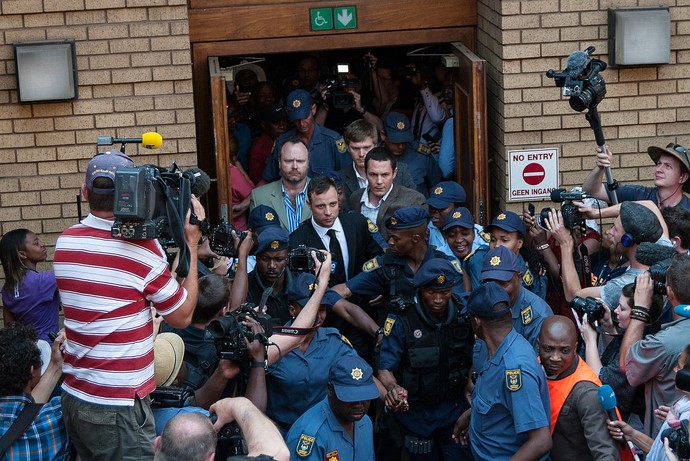 Oscar Pistorius cercado por policiais, jornalistas e curiosos após veredito do tribunal de Pretória (Foto: AFP)