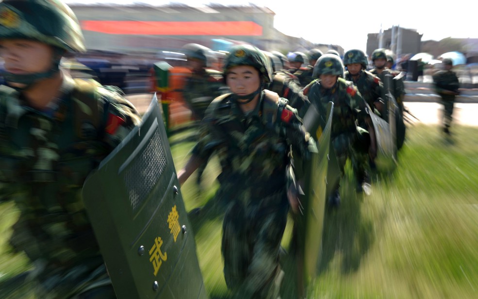 Força anti-terrorismo, incluindo a polícia de segurança pública e a polícia armada participam de um exercício anti-terrorismo conjunto em Hami, região de Xinjiang, noroeste da China. (Foto: AFP)