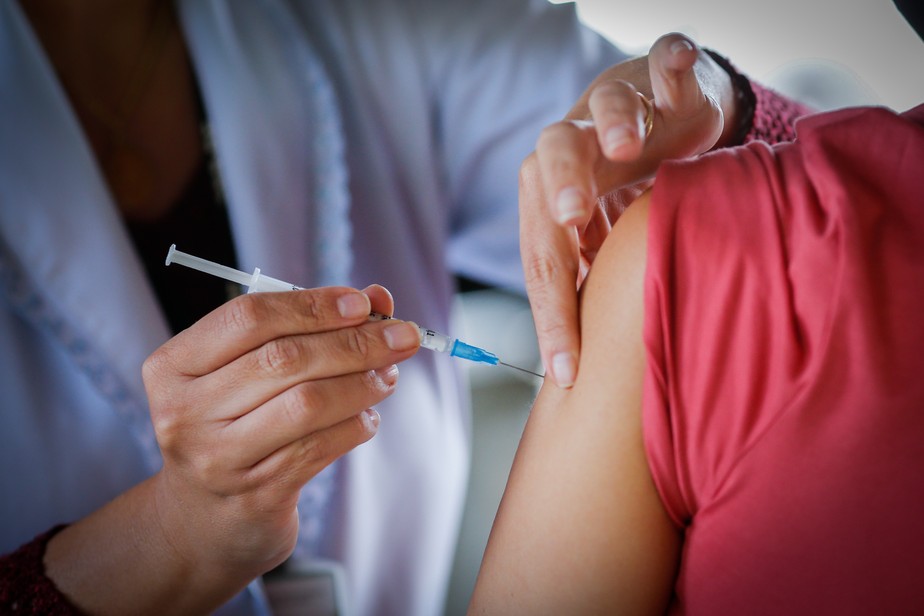 Profissional da saúde aplica dose de vacina em paciente em posto de saúde em Brasília
