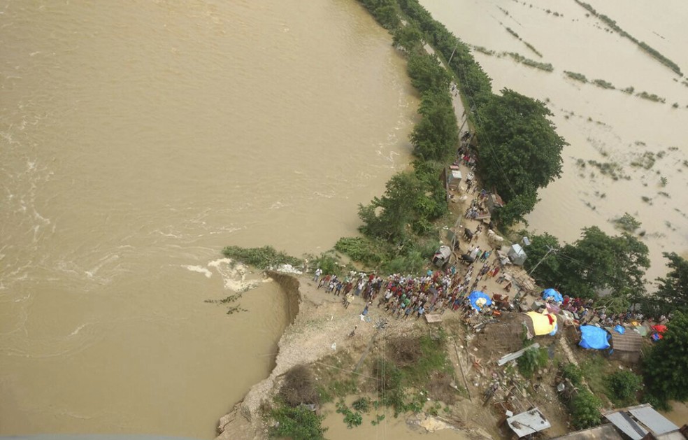 Vítimas da inundação esperam por resgate no distrito de Siddharmhnagar, no estado indiano do norte de Uttar Pradesh (Foto: National Disaster Response Force via AP)