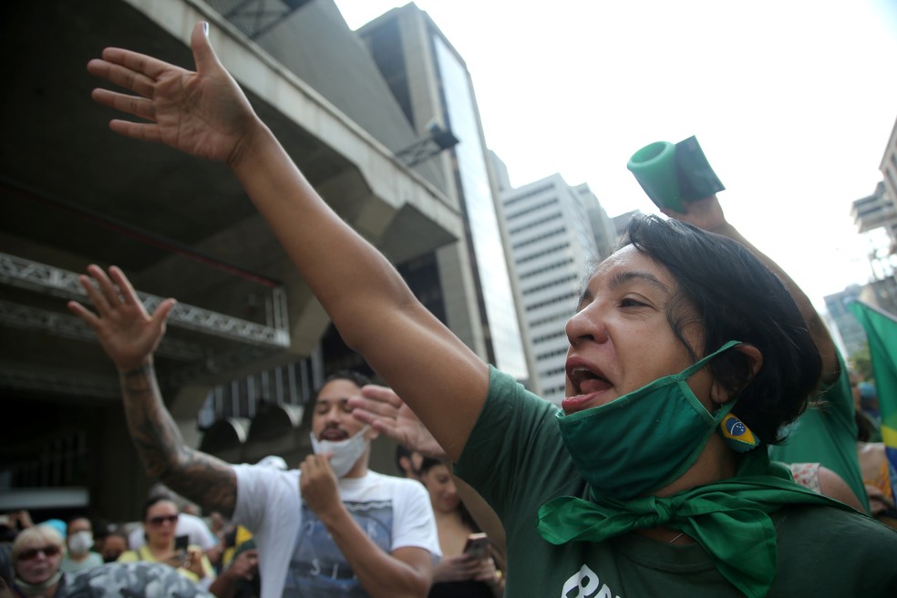 Manifestantes, com a máscara no queixo, protestam contra as medidas restritivas em São Paulo — Foto: Carla Carniel/Reuters