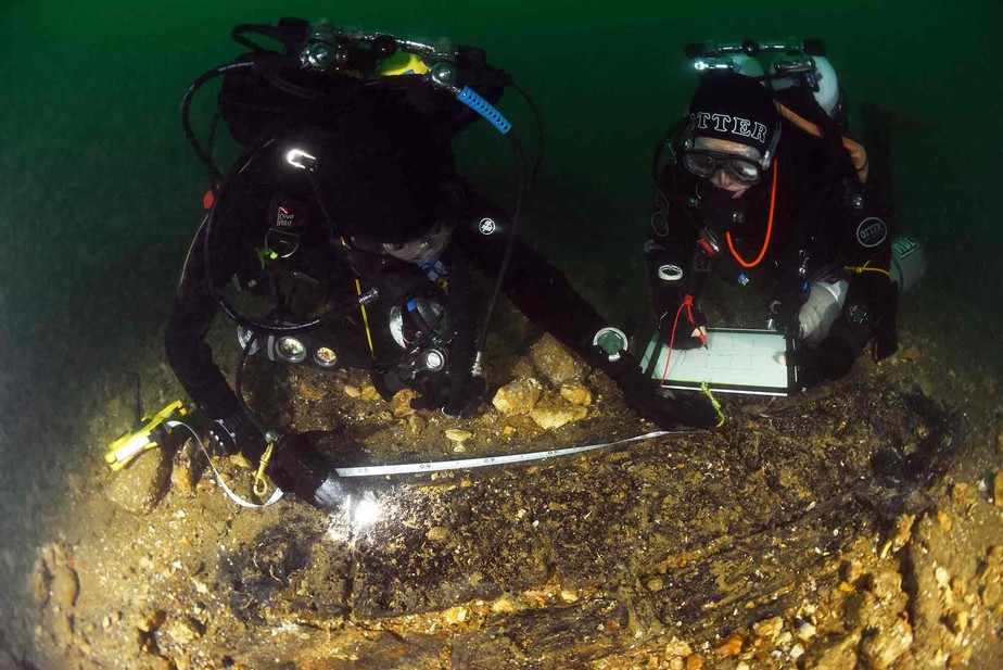 Mergulhadores da Sociedade de Arqueologia Náutica (NAS) medindo madeiras do 'Klein Hollandia'