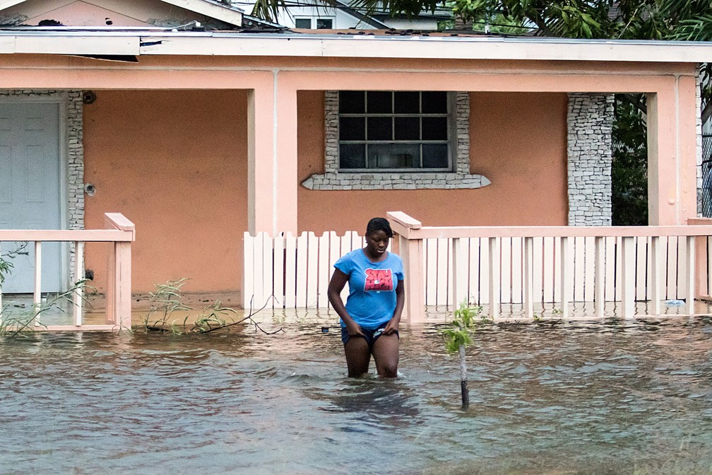 Mulher caminha em área alagada em Nasssau, nas Bahamas, na segunda-feira (2), na passagem do furacão Dorian — Foto: John Marc Nutt/ Reuters