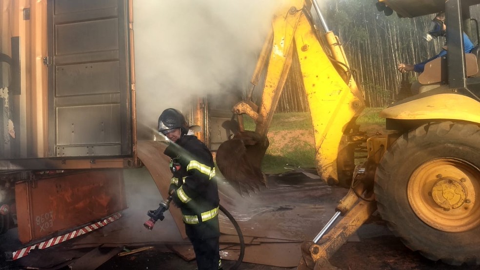Foi necessária uma retroescavadeira para retirar o material de chapas de madeira do caminhão em Botucatu — Foto: Corpo de Bombeiros / Divulgação