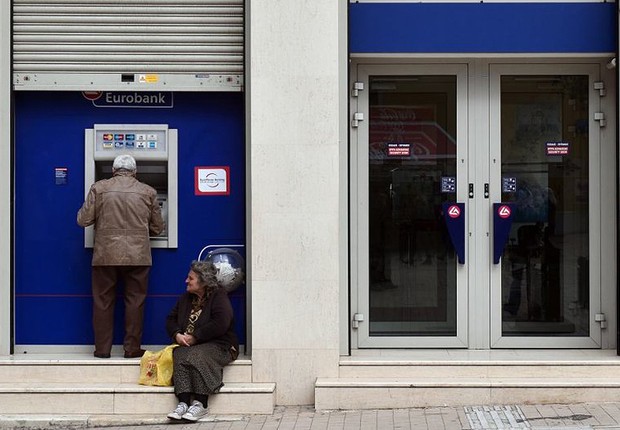 Homem saca dinheiro em caixa automático de Atenas, enquanto os bancos permanecem fechados por decisão do governo (Foto: Getty Images)