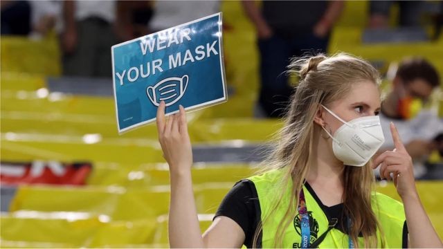 Fiscal de evento esportivo levanta o sinal de obrigatoriedade de uso de máscaras (Foto: ALEXANDER HASSENSTEIN/GETTY IMAGES via BBC)