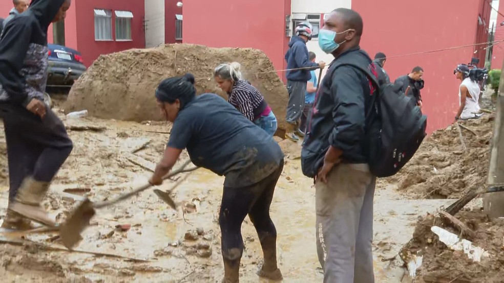 Mulheres usam pás e enxadas para revirar escombros em Petrópolis — Foto: Reprodução/ TV Globo