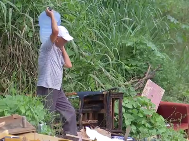 Moradores buscam água perto dos resíduos (Foto: Reprodução/ TV TEM)