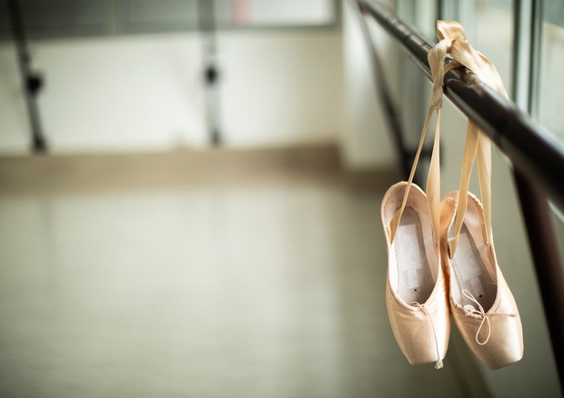 Ballet shoes hanging on a barre in a ballet studio, close up (Foto: Getty Images/iStockphoto)