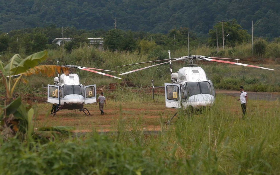Dois helicópteros esperam perto da caverna (Foto: Sakchai Lalit / AP Photo)