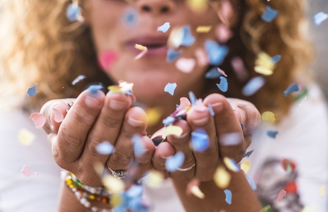 beautiful defocused woman blow confetti from hands. celebration and event concept. happiness and colored image. movement and happiness having fun (Foto: Getty Images/iStockphoto)