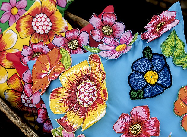 Almofadas: nos tecidos lisos são costuradas as mesmas flores recortadas da estampa de chita e, em algumas, são também feitas flores de crochê, como na azul, em destaque (Foto: Fabio Antonio Ronaldo/ Editora Globo)