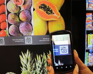 Para fazer a compra, usuário deve baixar aplicativo e posicionar celular em frente ao código do item desejado (Foto: Laura Brentano/G1)