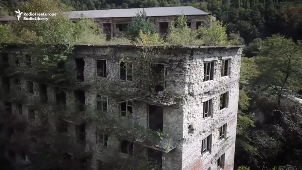 Floresta 'engoliu' prédios, casarões e hoje se mistura à arquitetura soviética em Akarmara — Foto: BBC