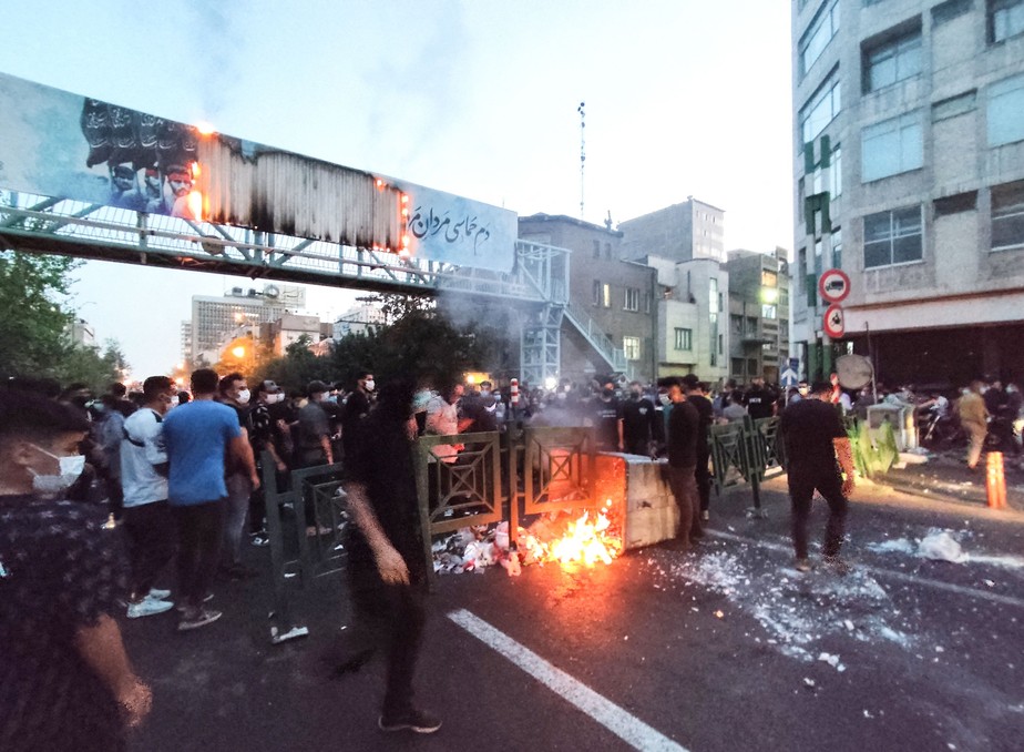 Foto de 21 de setembro de 2022 mostra manifestantes iranianos queimando uma lixeira na capital Teerã durante um protesto por Mahsa Amini, dias depois de ela morrer sob custódia da polícia da moralidade