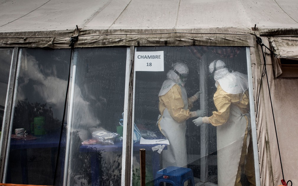 Agentes de saúde são vistos dentro de área reservada em centro de tratamento de ebola em Butembo, na República Democrática do Congo, em foto de 9 de março de 2019. O país voltou a registrar um caso da doença nesta sexta (10), após 52 dias — Foto: John Wessels/AFP