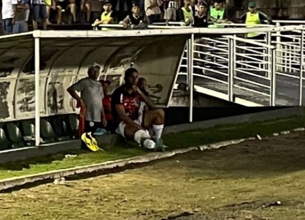 Luiz Fernando cabisbaixo no banco, com gelo no joelho direito — Foto: Phillipy Costa / Jornal da Paraíba